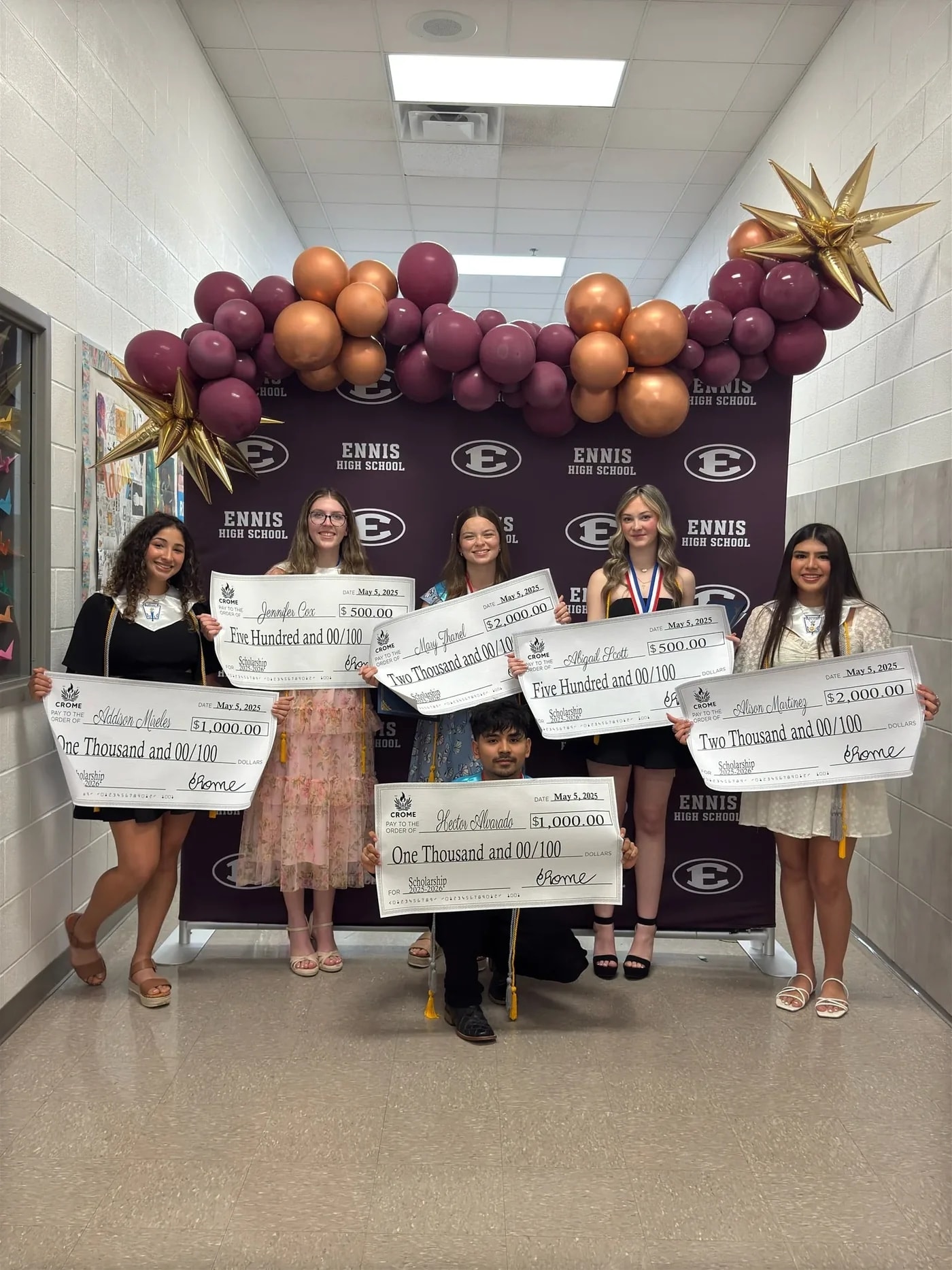CROME’s 2025 scholarship recipients holding their awards at Ennis High School