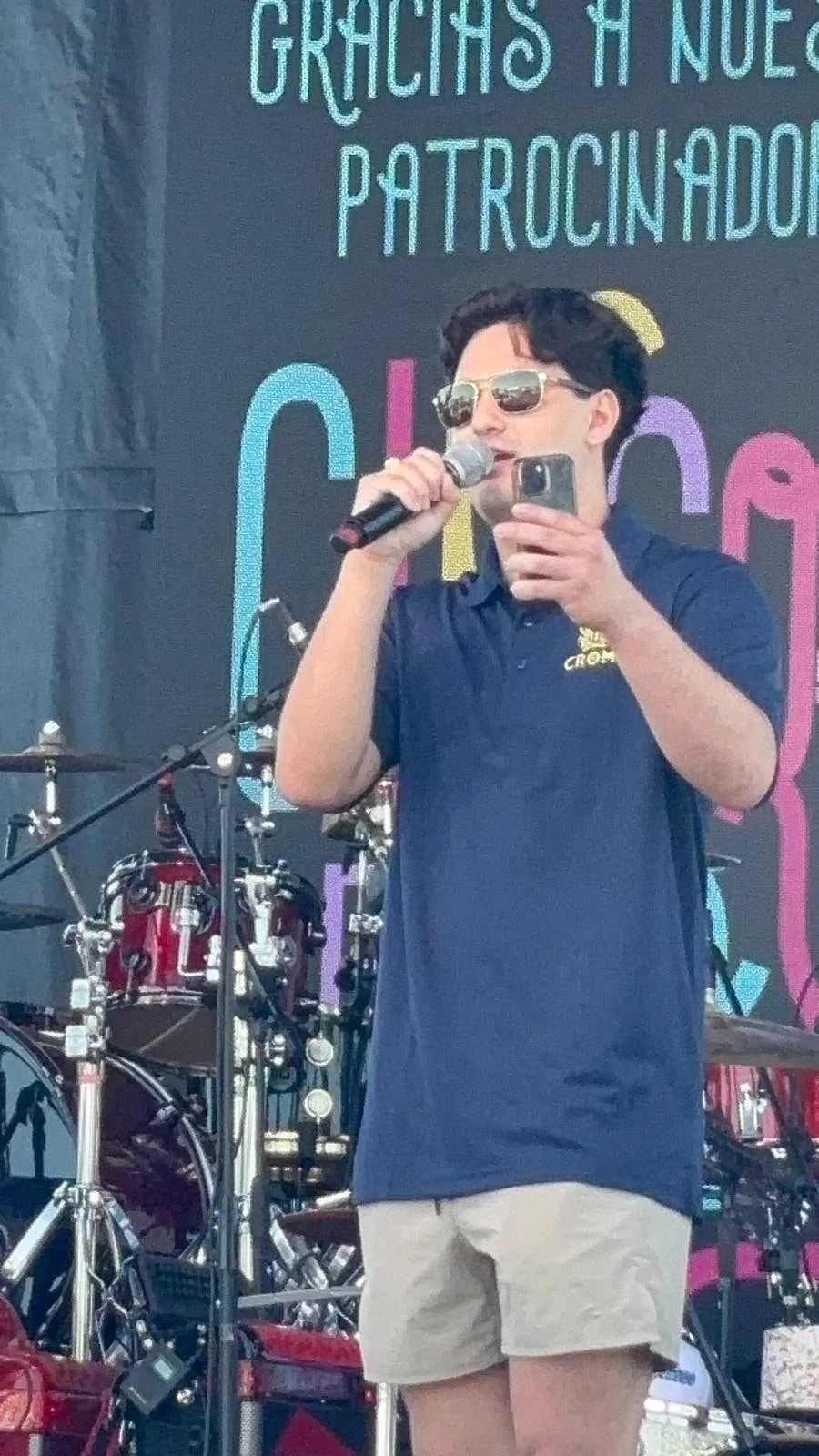 A CROME team member on stage at a community event, thanking sponsors